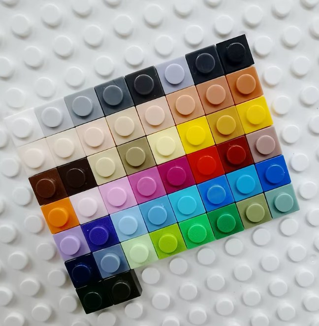 A sample of our individually numbered real brick colors laid out on a baseplate — our full color library runs well beyond what's pictured here